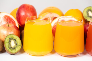 Different fruit juices in glasses on white background