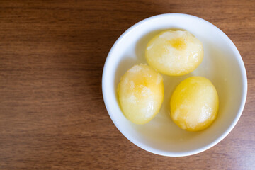 three peeled raw frozen eggs in bowl on table