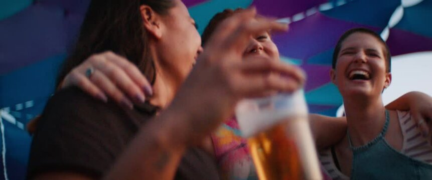 Young female best friends hugging at an outdoor festival