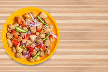 Healthy food vegetable salad on yellow plate on wooden table. Top view