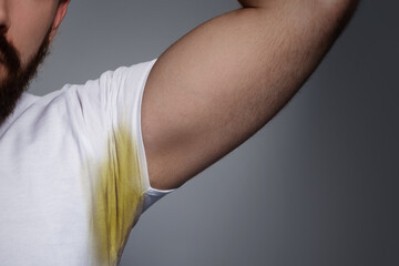 Man Lifting Arm Showing Yellow Stain on White Shirt