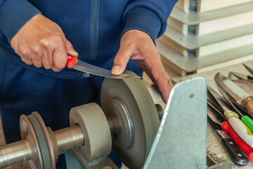 Man grinds abrasive cutting and sharpening stones for knives.Motion blur