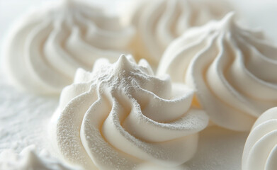 A close-up view of elegant, white meringue cookies artfully arranged on a plate.