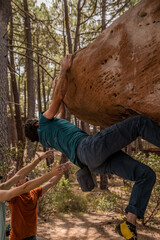 Climber in action on a steep rock in the pine forest of Albarracín. Extreme sports and bouldering...