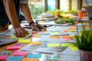Unrecognizable man works among colorful sticky notes in an office