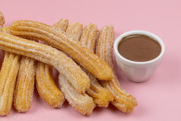 plusieurs churros, en gros plan, sur un fond rose