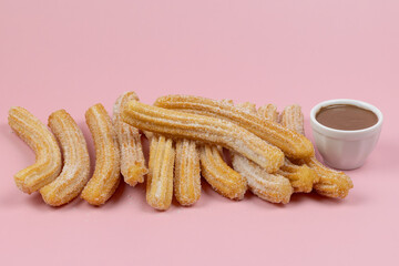 plusieurs churros, en gros plan, sur un fond rose