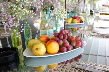 Several fruits are arranged on a table at a wedding party.
