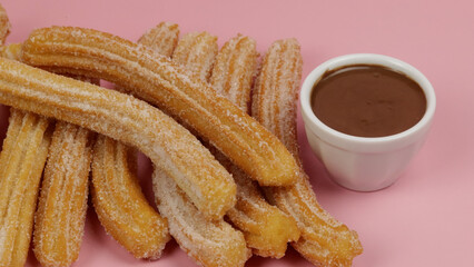 plusieurs churros, en gros plan, sur un fond rose