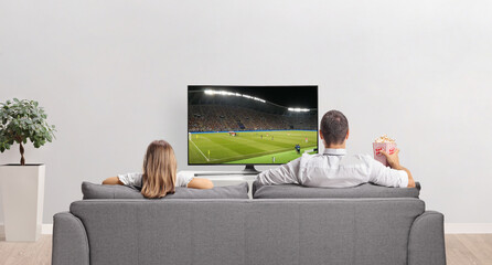 Father and daughter watching football on tv