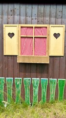 a window of an alpine hut with hearts