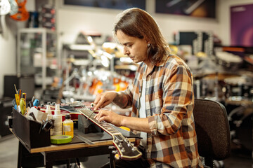 Man repairing electric guitar in a workshop