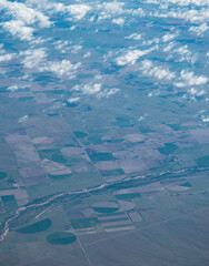 View of farmland from an airplane window over the USA.  Shapes created by center pivot irrigation systems. 