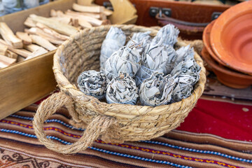 Obraz premium White sage also known as Salvia apiana, smudge sticks, herbal bundles in wicker basket, ceremonial use