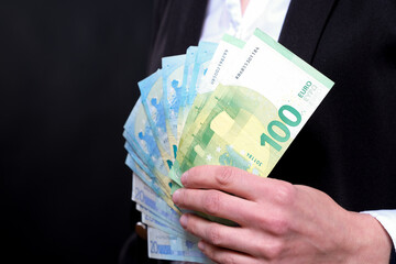 Unrecognizable business woman holds euro money and a leather wallet