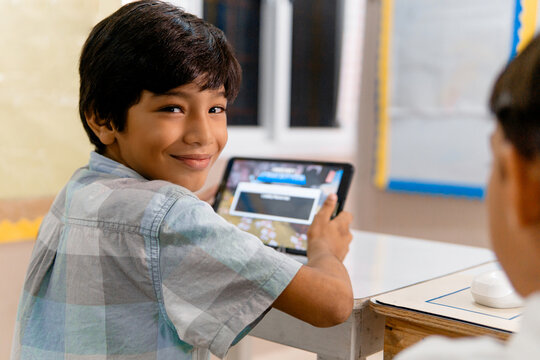 Portrait of Elementary Hispanic school Kids using tablet computers in class