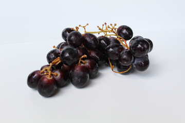 Dark purple grape with stem, isolated on white background