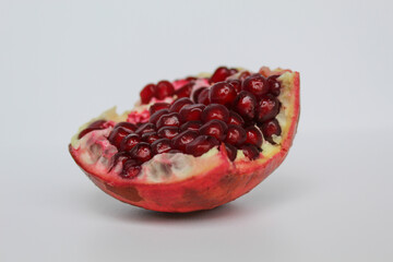 Inside of pomegranate fruit, fresh red seeds, isolated on white background
