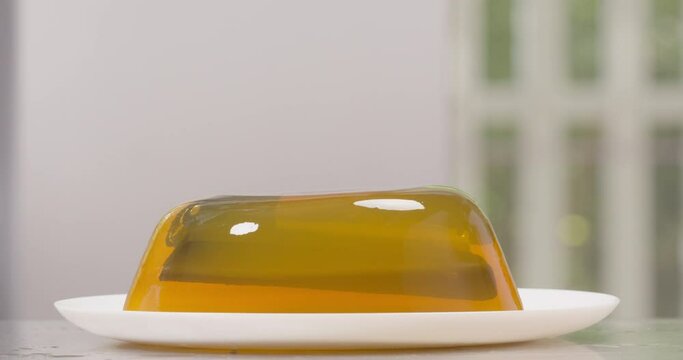 Male hands dropping stapler in jelly on to work surface