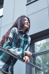 A young girl is leaning on the railing.