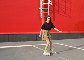 Full-length portrait of a smiling girl with long hair on roller skates