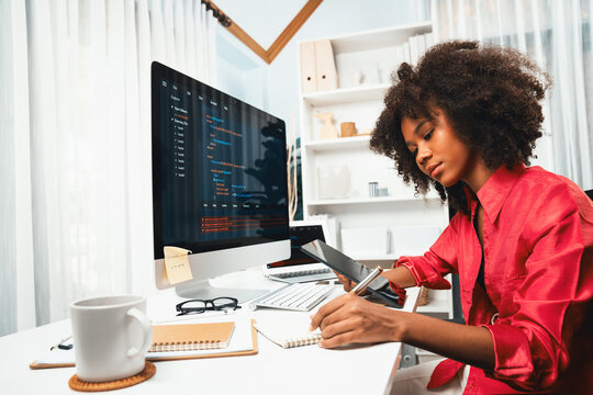Young working African woman creating coding website developer, thinking data information designer at home office, focusing on laptop Concept of analytical data center in java project job. Tastemaker.