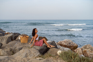 Woman Sitting on Rocks by the Sea