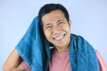 Smiling face expression young asian men wiping his hair with towel, looking at camera