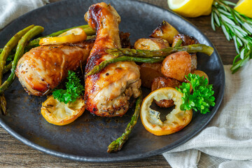 Lemon chicken drimsticks with baked potatoes and asparagus
