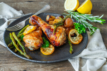 Lemon chicken drimsticks with baked potatoes and asparagus