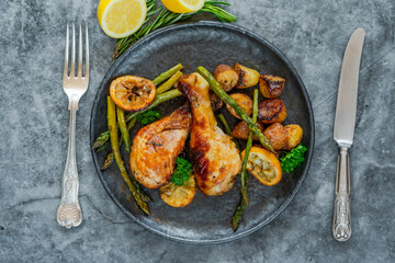 Lemon chicken drimsticks with baked potatoes and asparagus