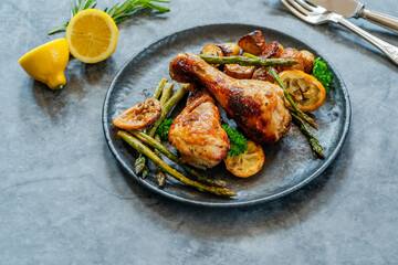 Lemon chicken drimsticks with baked potatoes and asparagus