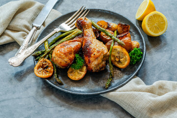 Lemon chicken drimsticks with baked potatoes and asparagus