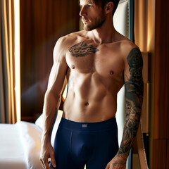 Model in men's dark blue cotton boxer briefs in a hotel bedroom