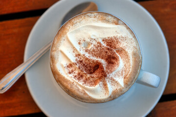 cappuccino with cream top view, on a wooden table