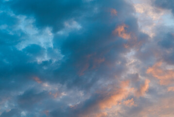 A plane cuts through the clouds as the sun sets in the background