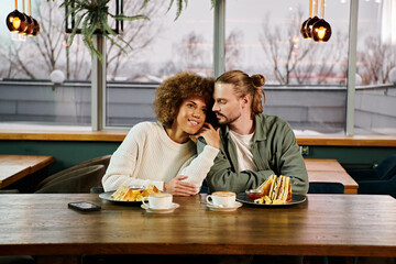 An African American woman and a man enjoying a meal together at a table in a modern cafe.