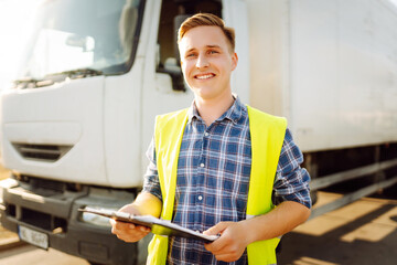 Portrait of truck driver in casual clothes standing in front of truck vehicles. Transport industry theme. Logistics. Distribution and warehouse service