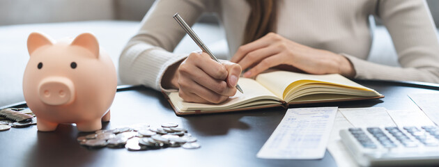 Saving money wealth concept, asian young business woman hand write management budget for saving...