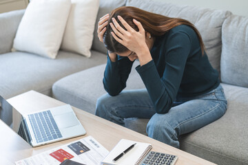Financial owe asian woman sitting stressed by calculate expense at home, looking at invoice or...