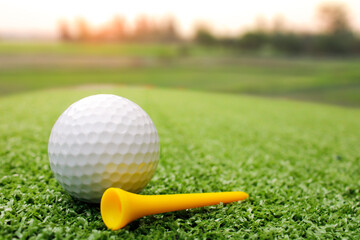 The golf ball is placed on the grass next to the tee.