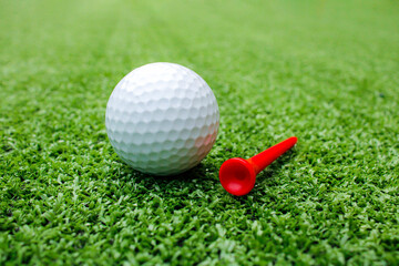 Golf balls and tees are placed on artificial grass.