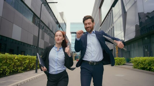 Happy business people colleagues running in city office freedom wow reaction achievement triumph win success joy fun jumping yelling with happiness Caucasian happy businessman businesswoman victory