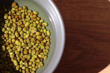 moong dal soaked in water in a grey bowl. Raw Lentil kept in the water bowl 