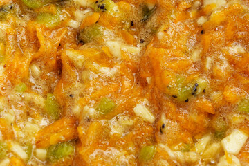 Fresh healthy dough from carrot and pieces of fruit such as banana and kiwi for preparing diet muffins