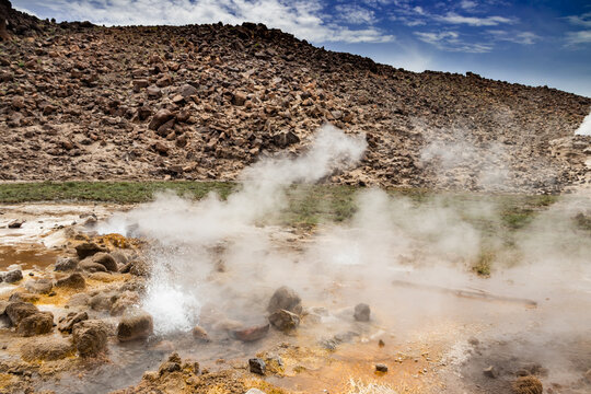 Alolabad geothermal area in Ethiopia with surreal landscape of colorful hot springs, steaming fumaroles, and erupting salt geysers in an arid, remote desert setting below sea level, Afar desert. 
