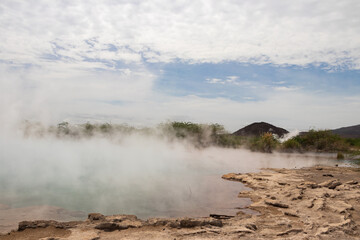 Alolabad geothermal area in Ethiopia with surreal landscape of colorful hot springs, steaming fumaroles, and erupting salt geysers in an arid, remote desert setting below sea level, Afar desert. 