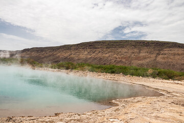 Alolabad geothermal area in Ethiopia with surreal landscape of colorful hot springs, steaming fumaroles, and erupting salt geysers in an arid, remote desert setting below sea level, Afar desert. 