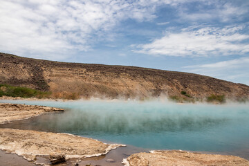 Alolabad geothermal area in Ethiopia with surreal landscape of colorful hot springs, steaming fumaroles, and erupting salt geysers in an arid, remote desert setting below sea level, Afar desert