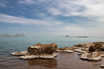 Alolabad geothermal area in Ethiopia with surreal landscape of colorful hot springs, steaming fumaroles, and erupting salt geysers in an arid, remote desert setting below sea level, Afar desert